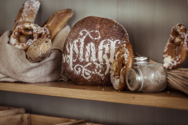 Nachhaltig produzierte Backwaren wie Brezen und Sauerteig-Brot in einem Regal.