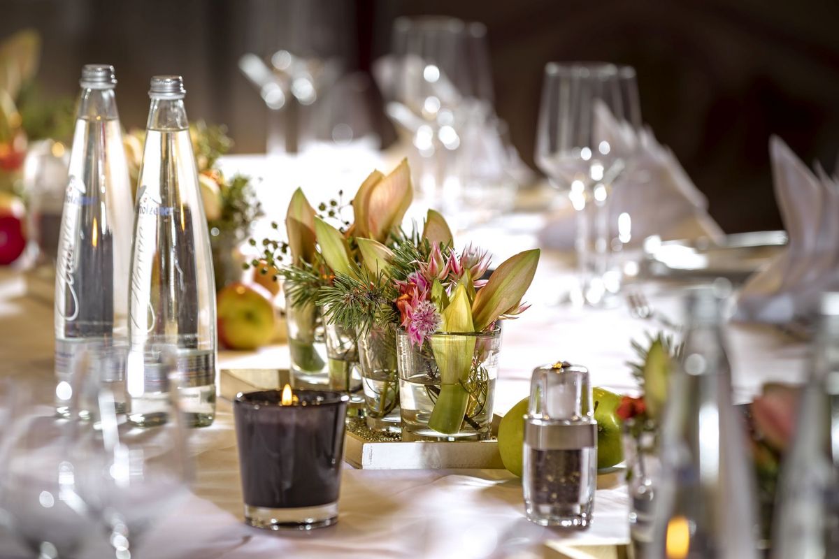 Ein, für eine Private Feierlichkeit im Platzl Hotel München, eingedeckter Tisch mit Servietten, Kerzen und Wasserflaschen