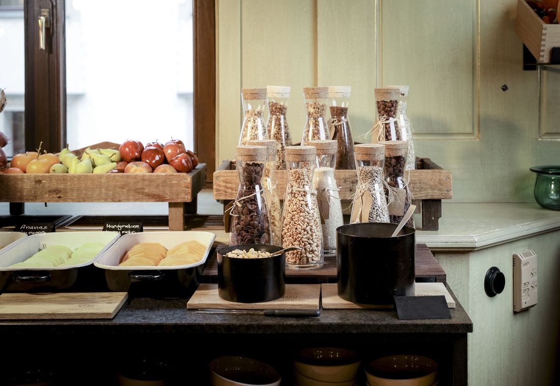 Müsli, Nüsse und frisches Obst in rustikaler Frühstücksecke mit Glasbehältern
