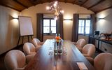 Cozy boardroom setup with chandelier, flipchart, and refreshments