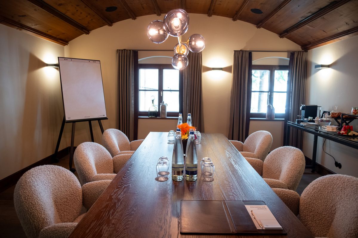 Cozy boardroom setup with chandelier, flipchart, and refreshments