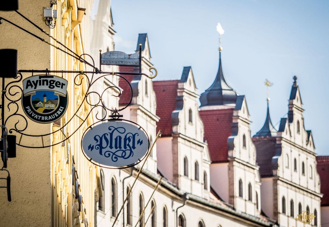 Das Platzl Hotels Schild hängt vor der historischen Gebäudefassade im Herzen Münchens