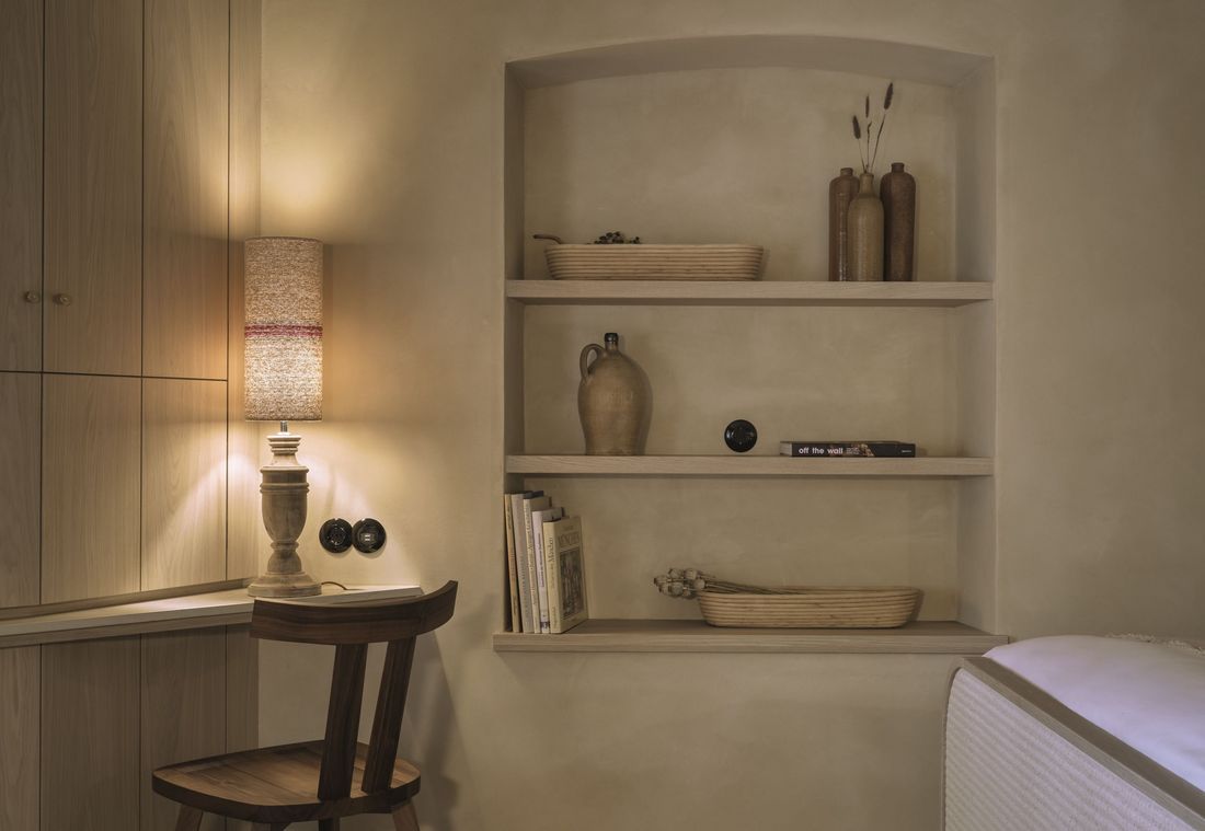 In warmem Licht erleuchtete Regalnische mit Keramikvasen in einer stilvollen Suite in München