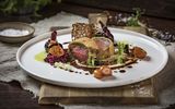 A plate with a fillet of beef and several side dishes on a wooden board at the Platzl Hotel Munich