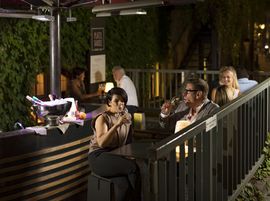 Eine Frau und ein Mann genießen ein Glas Wein in der Außenbar Josefa Karree.