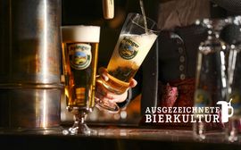 A waitress pours a glass of beer from the barrel in the popular Wirtshaus Ayinger am Platzl.