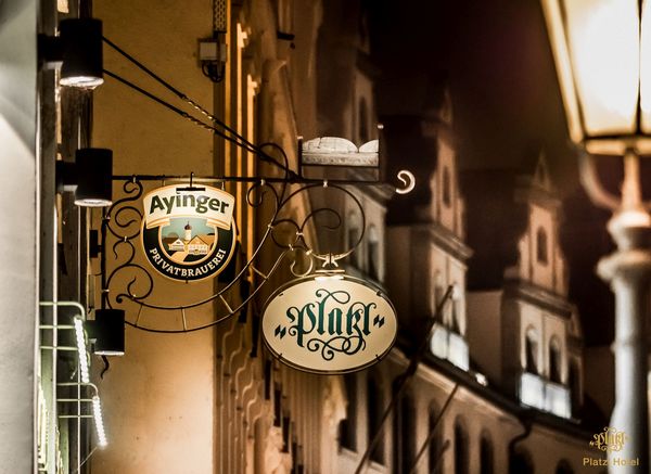 A nightly shot of the illuminated sign of the Platzl Hotel Munich