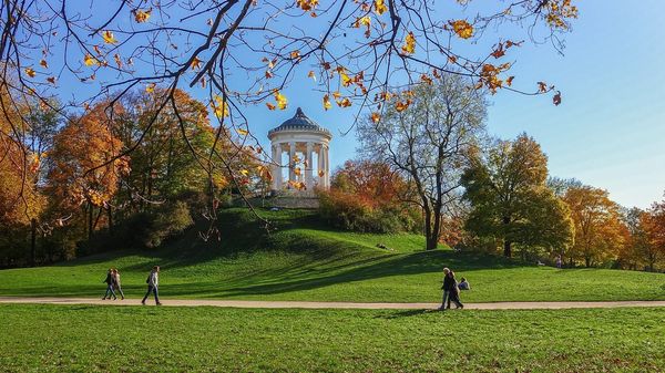 People walk past the Monopteros in the English Garden in Munich. 