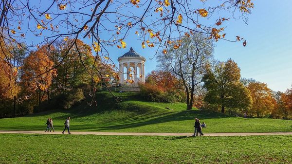Herbstlicher Park in München, auf einem Hügel ist ein Säulenpavillon situiert