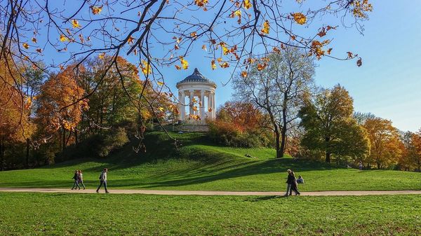 Herbstlicher Park in München, auf einem Hügel ist ein Säulenpavillon situiert