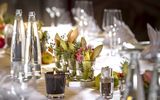 Ein, für eine Private Feierlichkeit im Platzl Hotel München, eingedeckter Tisch mit Servietten, Kerzen und Wasserflaschen
