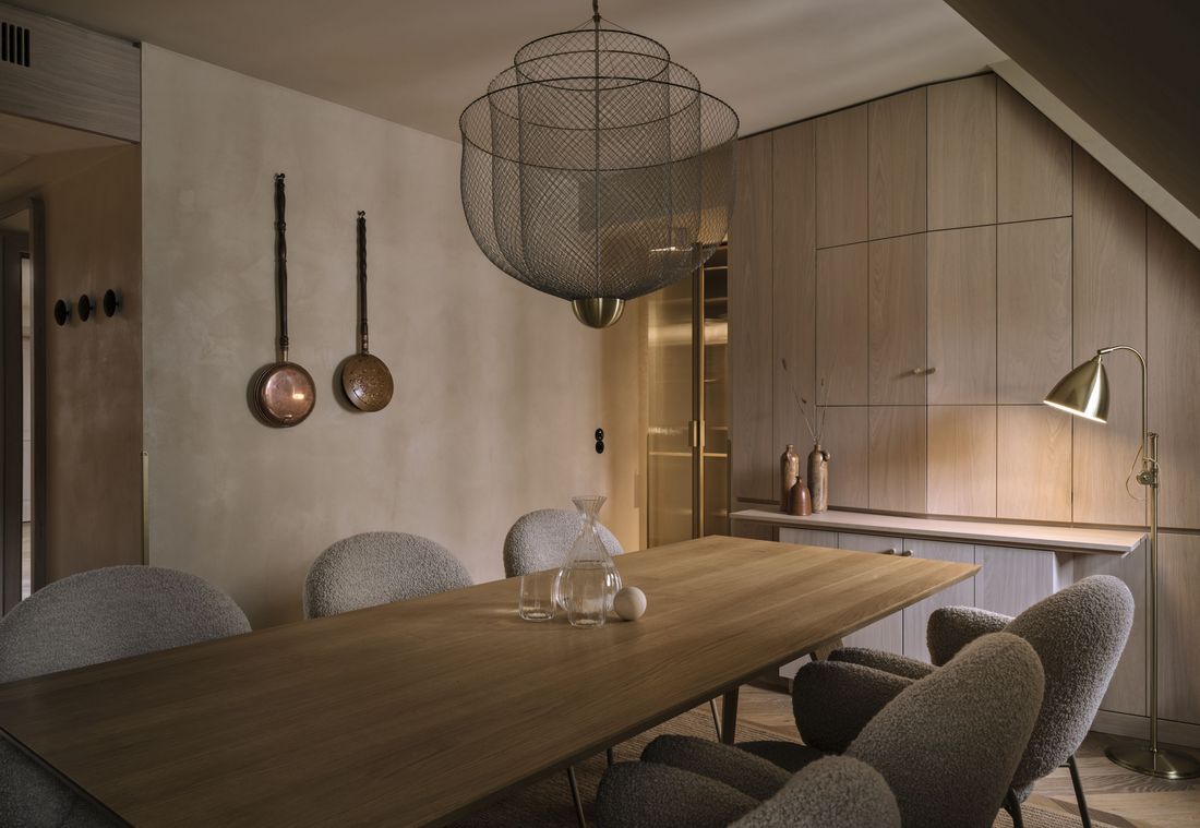 Design-Esszimmer mit runden Stühlen und filigraner Hängelampe in einer Suite in München