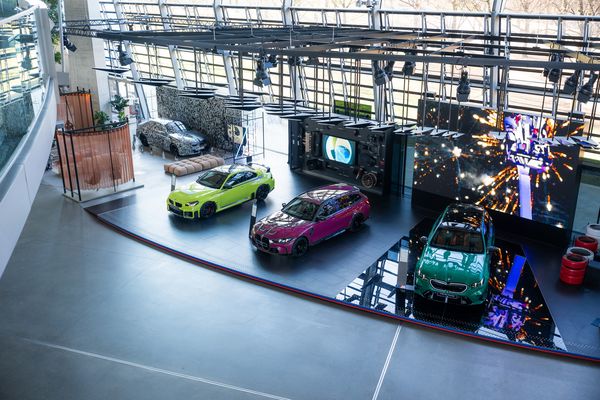 Moderne Ausstellung im BMW Museum in München mit bunten Fahrzeugen und interaktiven Displays in einem futuristischen Raum.