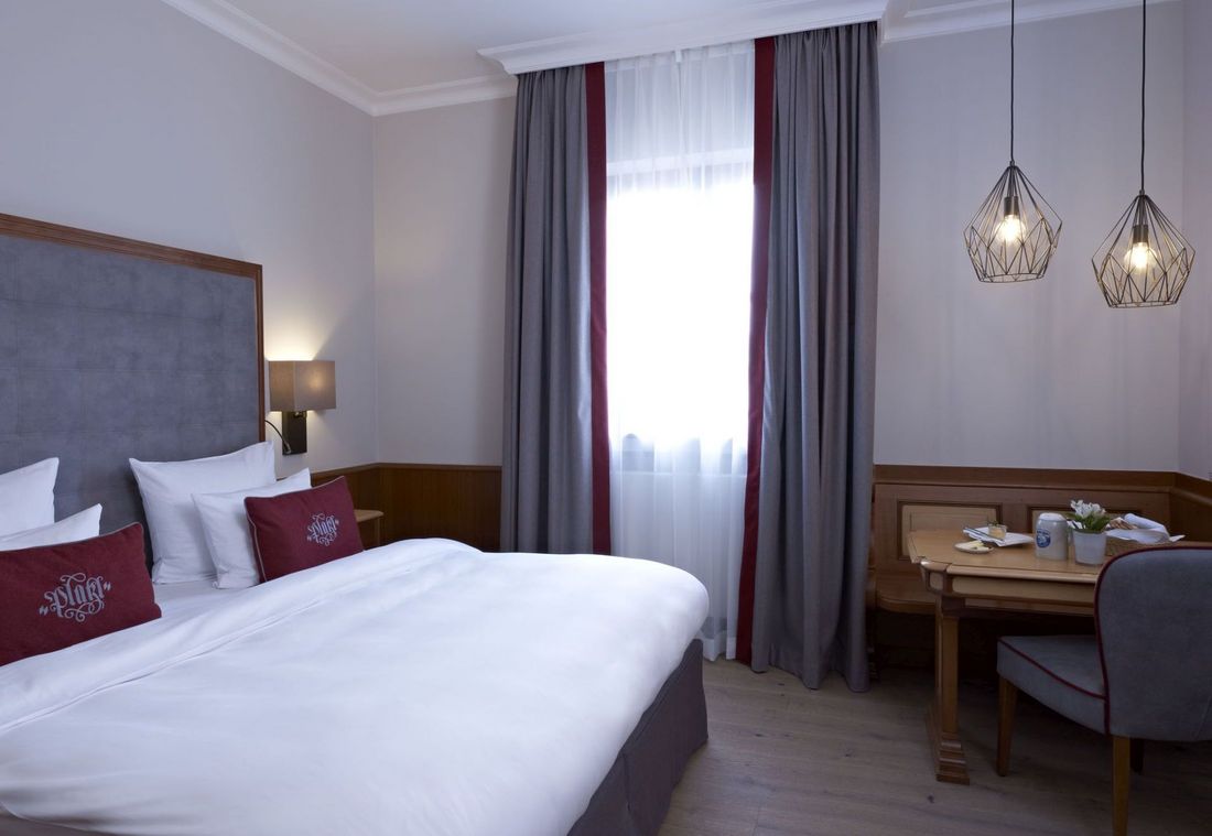 Das stilvolle Zimmer bietet eine helle Sitzecke mit Holzdetails und modernen Hängelampen
