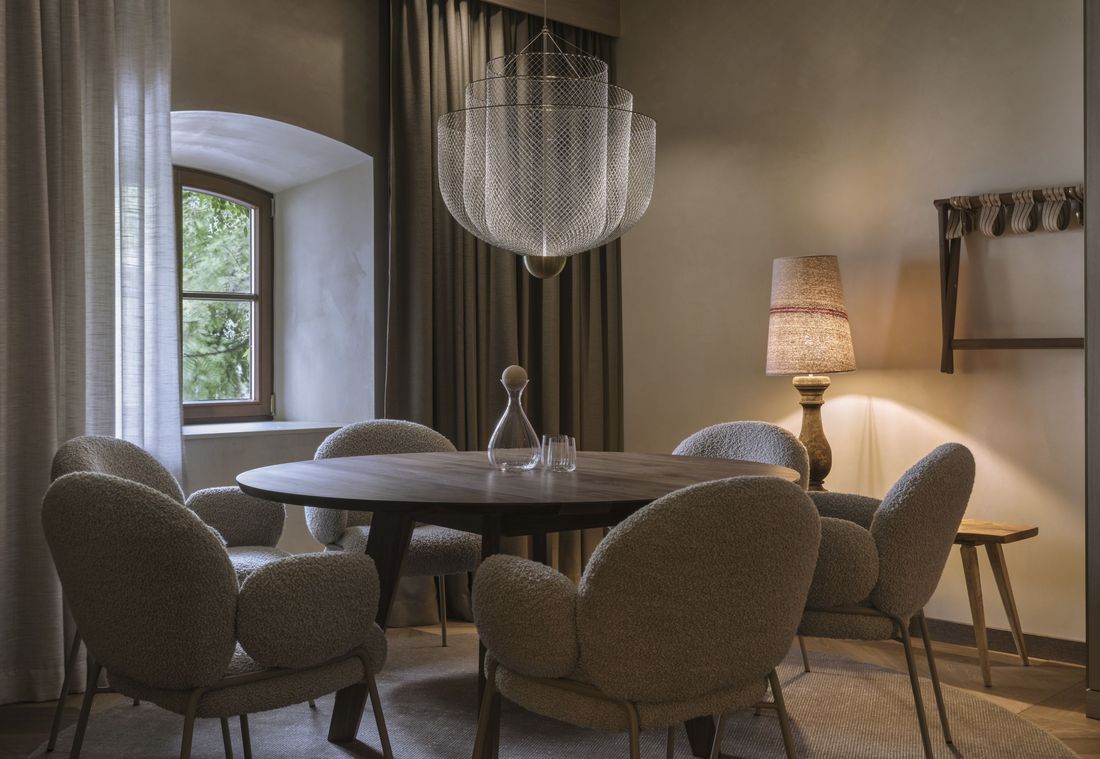 Großer Esstisch vor Fenster mit Blick ins Grüne in einer stilvoll eingerichteten Suite in München