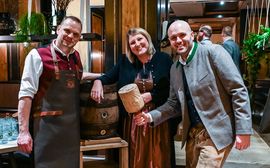 Relaunch 16.2.23 K. Kramer and her colleagues standing in front of a beer keg in Bavarian traditional costume.