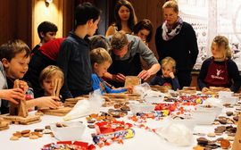 Children & young adults baking cookies with representatives of the Nicolaidis YoungWings Foundation.