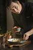 A chef is busy garnishing a dish at the Platzl Hotel Munich