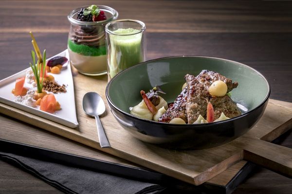 Kunstvoll angerichtete Mahlzeit im Tagungshotel München mit Vorspeise, einem Fleischgericht als Hauptgang und einem Dessert in einem kleinen Weckglas.