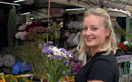 A young woman with a bouquet of flowers at the Viktualienmarkt