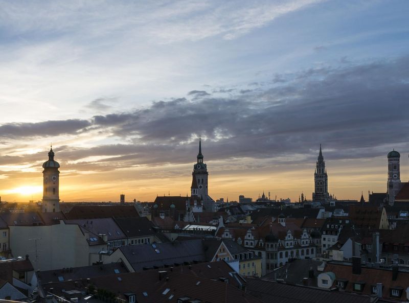 Skyline of Munich in the sunset with the towers of the Holy Spirit Church, the Old Peter and the Old and New City Hall. 