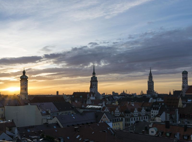 Skyline of Munich in the sunset with the towers of the Holy Spirit Church, the Old Peter and the Old and New City Hall.