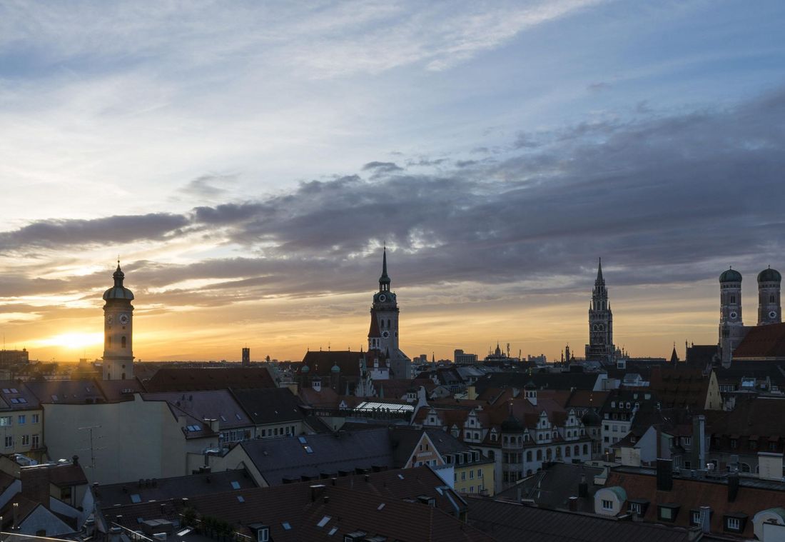 Die Türme und Dächer der Münchner Altstadt erscheinen im Licht der untergehenden Sonne