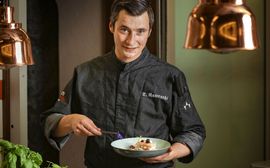 Sous chef Tino Nawrocki presents a dessert arranged in a deep plate.
