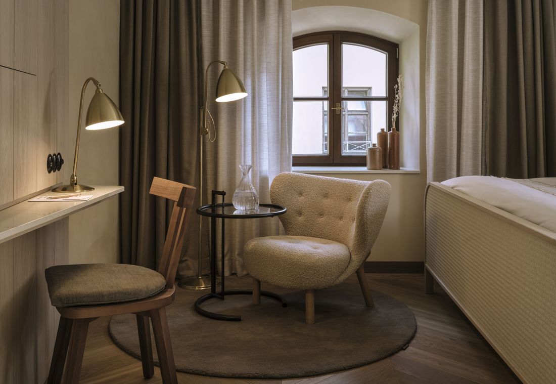 Ein stilvoller Arbeits- und Ruhebereich in der Suite in München mit Schreibtisch und Designstuhl