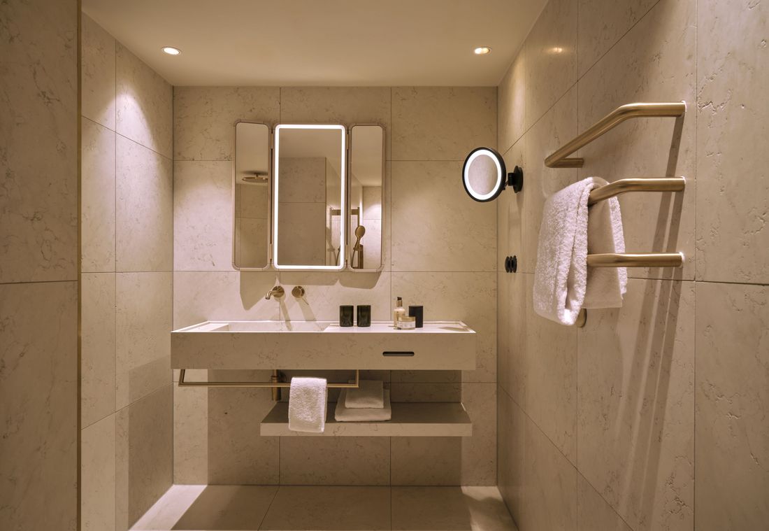 Die Suite in München ist mit einem eleganten Bad samt beleuchtetem Spiegel und hochwertigen Pflegeprodukten ausgestattet