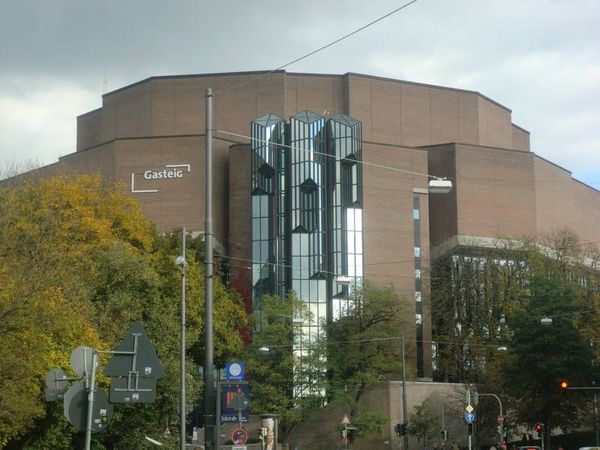 Das dunkle Gebäude der Philharmonie in München mit einigen Bäumen davor