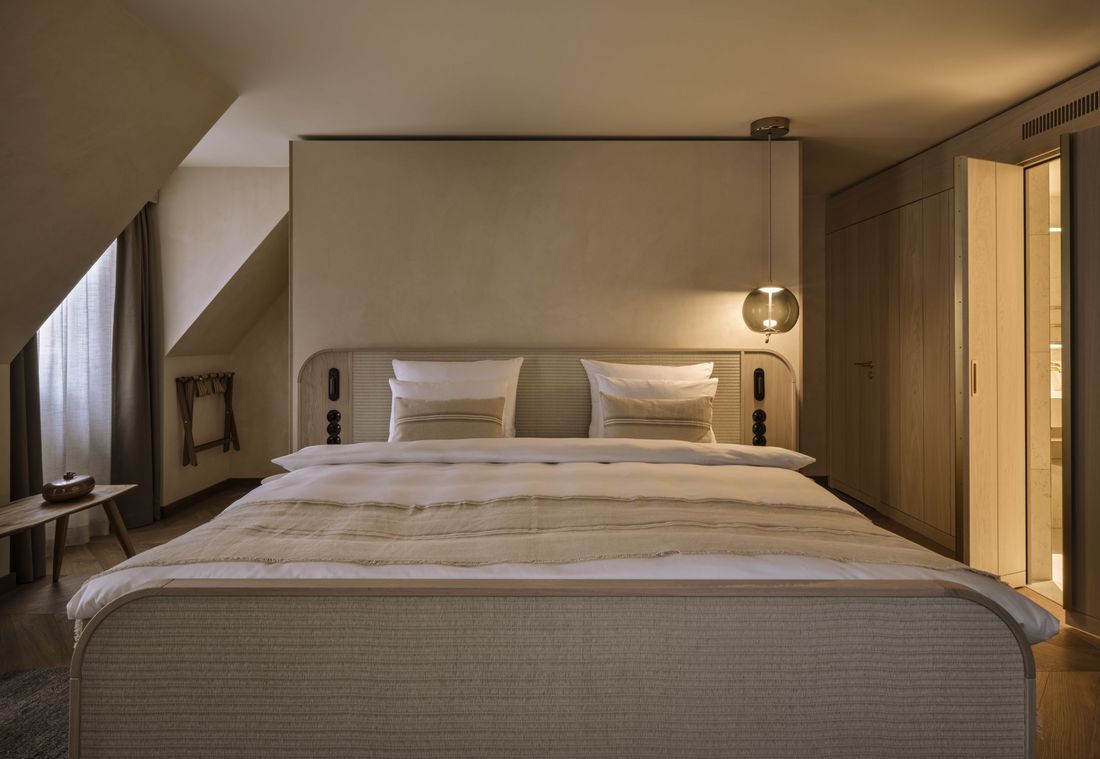 Die Suite in München überzeugt mit einem komfortablen Doppelbett und stimmungsvoller Beleuchtung