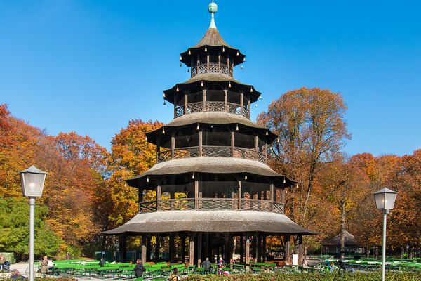 vDer Chinesische Turm umringt von herbstlichen Laubbäumen im Englischen Garten in München