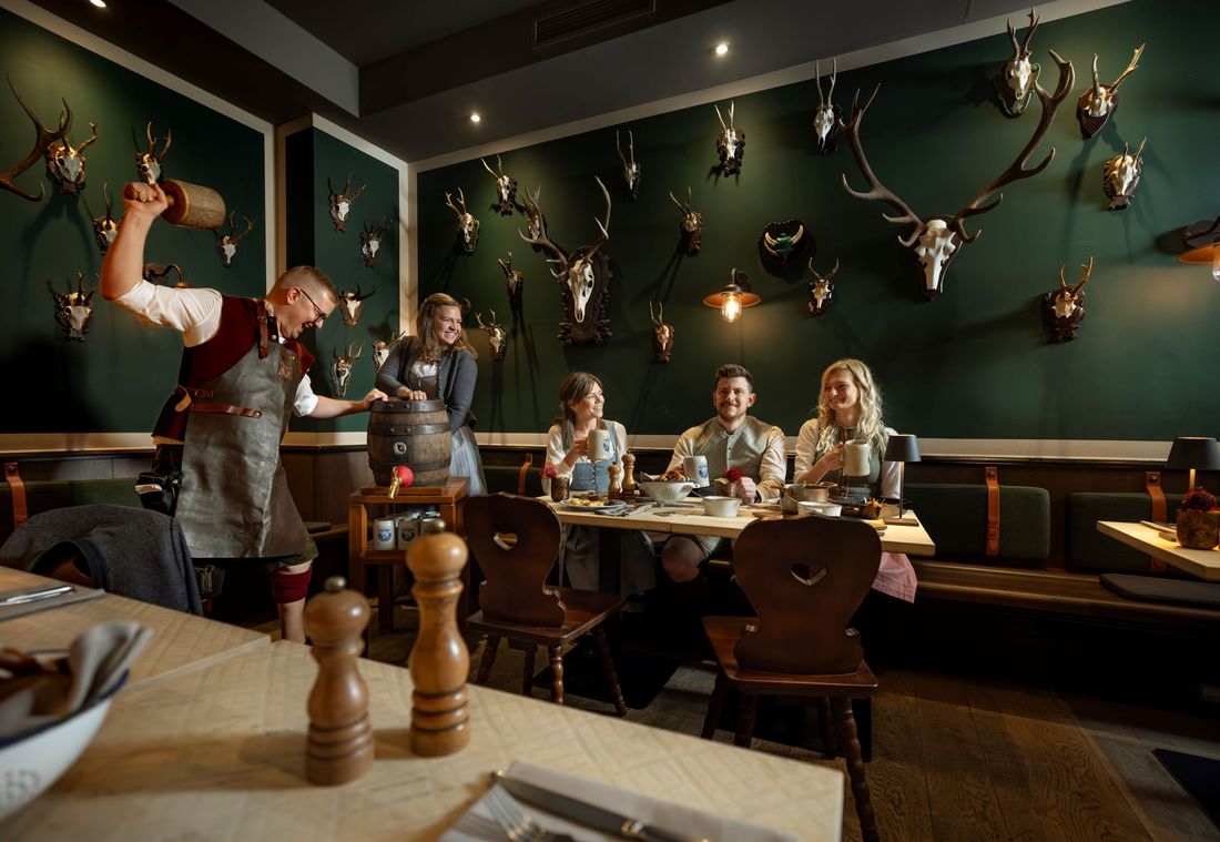 Group in traditional clothing enjoying Bavarian meal in a rustic dining room